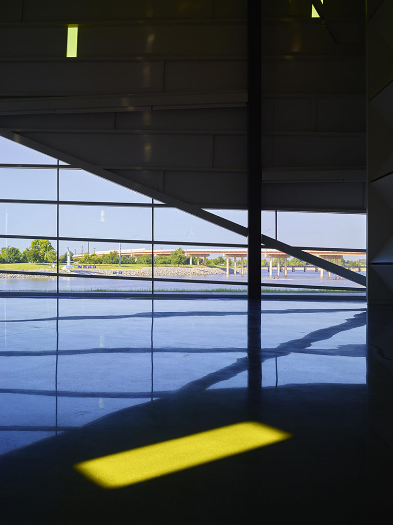 Architectural interior of the UCO Boathouse with angular forms and river reflections at the CHK | UCO Boathouse for UCO women’s rowing