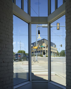 PLICO at the Flatiron reflected in glass from across the street