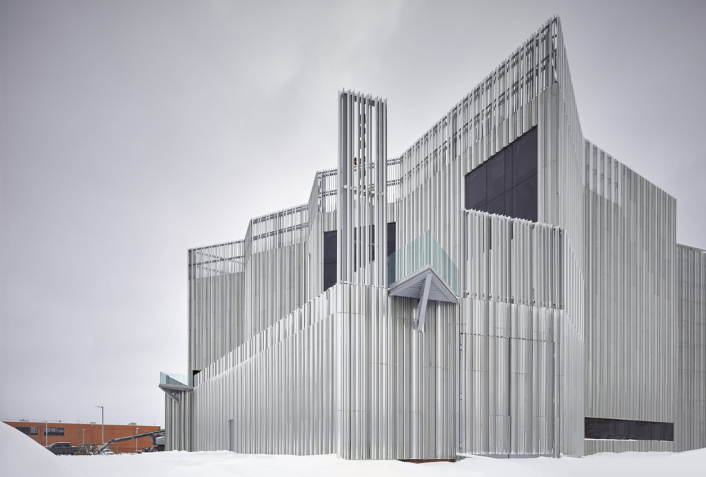 The Oklahoma Contemporary Arts Center on a snowy day, showcasing its vertical aluminum fins and architectural design under an overcast sky.
